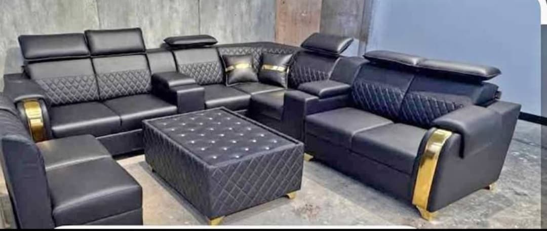 Black leather corner sofa set with gold trim and glass table