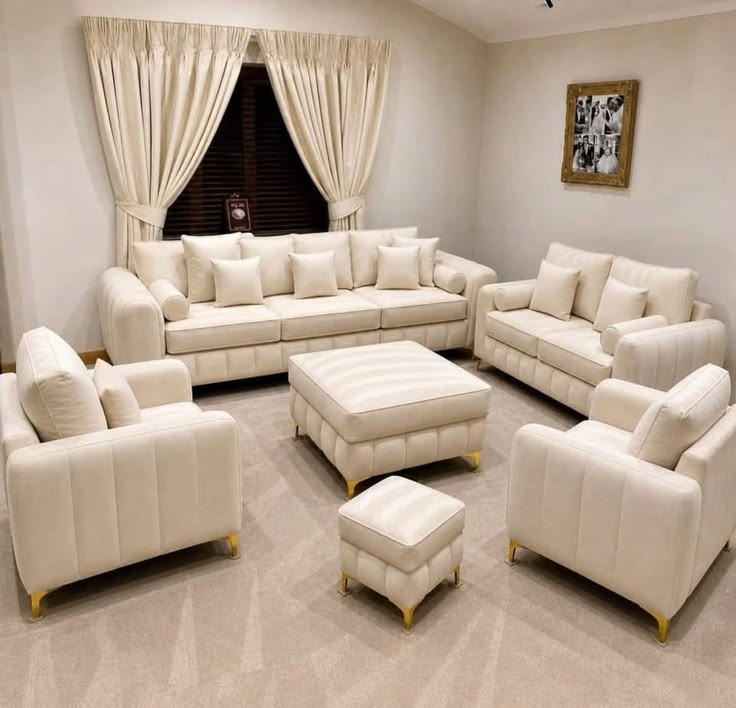 Ivory sofa, loveseat, and two armchairs with ottomans in a living room