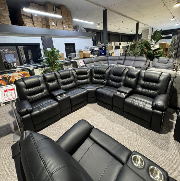 Black leather reclining corner sofa set in showroom